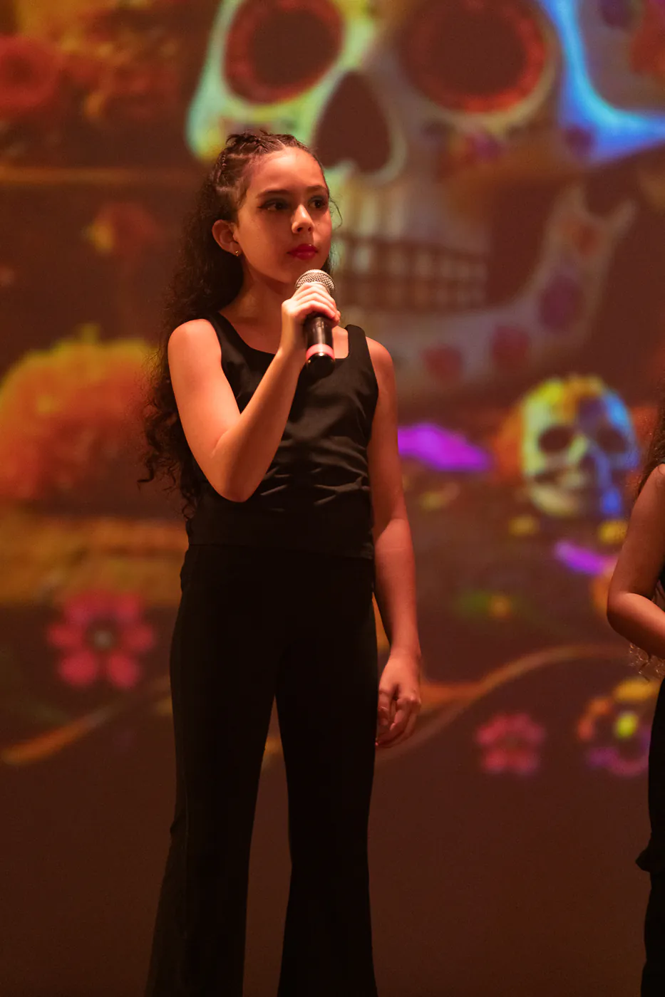 Alumna de Faith cantando con escenografía de Día de Muertos