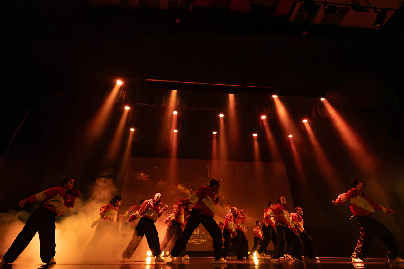Coreografía grupal de Faith entre luces cálidas y humo