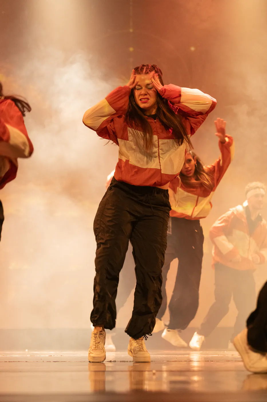Bailarina de Faith bailando hip hop entre luces anaranjadas