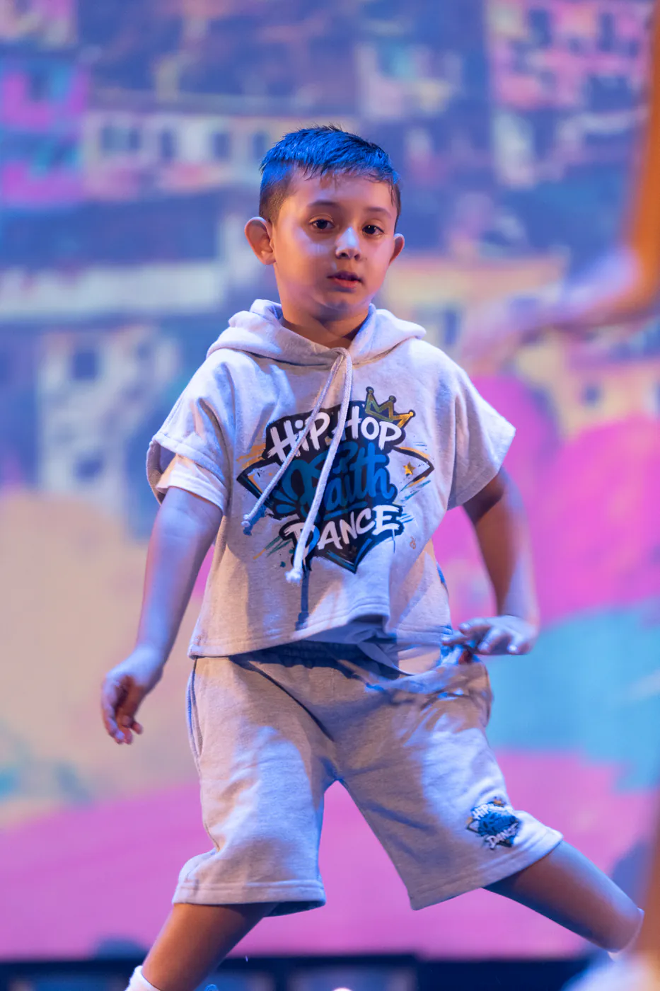 Niño de Faith bailando hip hop con la camiseta de la academia